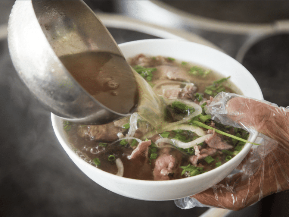 chef filling bowl of pho